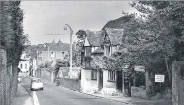  ??  ?? Locals were up in arms when permission was given for the demolition of the picturesqu­e cottage of Mummery’s the seedsman in East Hill in 1962. It was to be replaced by a car park for Ashford School, which has for many years occupied almost all of the...