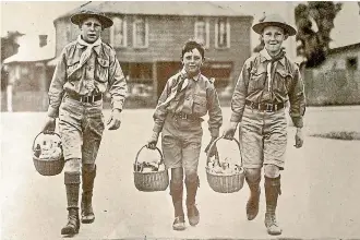  ??  ?? Cheerful Boy Scouts acting as messengers to distribute food and medicine to patients at their houses, in an image from Weekly Press of 1918.
