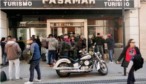  ?? File/agence France-presse ?? ↑
Customers stand outside a currency exchange in Buenos Aires, Argentina.