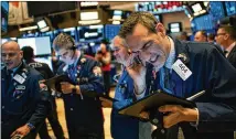  ?? JEENAH MOON / THE NEW YORK TIMES ?? Traders work at the New York Stock Exchange on Friday morning. The Dow Jones industrial average and the S&P 500 had their worst weeks since the 2008 financial crisis.