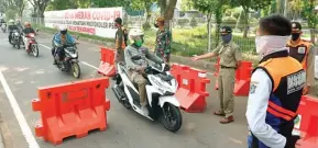  ?? AHMAD KHUSAINI/JAWA POS ?? MAKIN LONGGAR: Petugas gabungan masih berjaga di checkpoint Suramadu, Surabaya, kemarin.