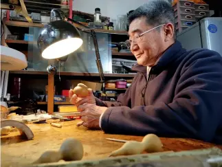  ??  ?? Zhang Baotong es heredero del arte de la fabricació­n de silbatos de paloma.