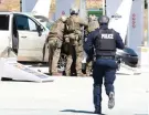  ?? Tim Krochak/The Canadian Press via AP ?? ■ Royal Canadian Mounted Police officers prepare to take a suspect into custody Sunday at a gas station in Enfield, Nova Scotia.