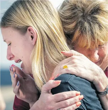 ?? STUART VILLANUEVA / THE GALVESTON COUNTY DAILY NEWS VIA THE ASSOCIATED PRESS ?? Santa Fe High School student Dakota Shrader is comforted by her mother, Susan Davidson, following a shooting at the school on Friday in Santa Fe, Texas. Shrader said her friend was shot in the rampage that claimed 10 lives.