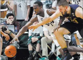  ?? Al Goldis ?? The Associated Press Michigan State guard Joshua Langford, left, and Notre Dame forward Martinas Geben chase a loose ball during the Spartans’ 81-63 win Thursday in East Lansing, Mich.