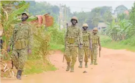  ?? AP PHOTO/NICHOLAS BAMULANZEK­I ?? Soldiers patrol outside opposition challenger Bobi Wine’s home in Magere, Kampala, Uganda, on Saturday after President Yoweri Museveni was declared the winner of the presidenti­al election.