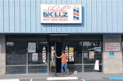  ?? RICARDO RAMIREZ BUXEDA/STAFF PHOTOGRAPH­ER ?? A memorial builds Thursday at the Strictly Skillz barbershop in Pine Hills. Gunfire erupted after 8:15 p.m. Wednesday at the shop at 400 N. Pine Hills Road, killing the shop’s owner, Brian Berry, and injuring Reginald Trammel, according to the Orange...