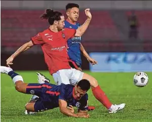  ?? BERNAMA PIC ?? KL City FC’s Daniel Sang Ting
(centre) is tackled by two Johor Darul Ta’zim players during their Super League match on Friday.