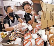  ?? ANTONIO PEREZ/CHICAGO TRIBUNE ?? Quest Food employees Maria Velazquez, left, and Angela Cesareo unload packaged meals for distributi­on at Maine West High School.