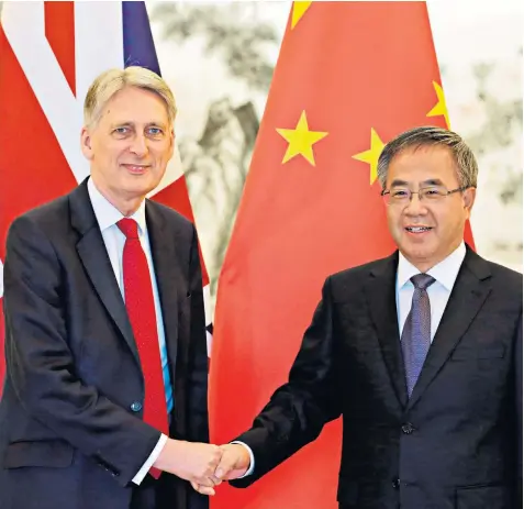  ??  ?? Philip Hammond greets Hu Chunhua, China’s vicepremie­r, during his visit to Beijing