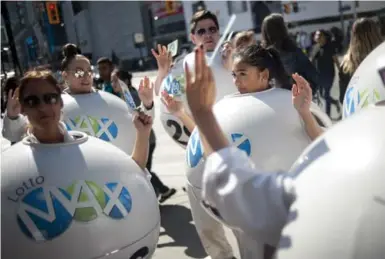  ?? MARTA IWANEK/THE CANADIAN PRESS FILE PHOTO ?? Promoters in Yonge-Dundas Square drum up excitement ahead of a Lotto-Max draw last September. Financial experts say that anyone lucky enough to win a jackpot should start with a cooling-off period, then think through how to spend their winnings.