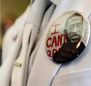  ?? Associated Press ?? A button that reads “I can’t breathe” adorns the jacket of a mourner before the June 9, 2020, funeral for George Floyd in Houston. Political observers are watching whether Texas’ governor will posthumous­ly pardon Floyd for a 2004 arrest before the end of the year.