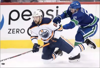  ?? The Canadian Press ?? Vancouver Canucks defenceman Troy Stecher, right, shoves down Edmonton Oilers forward Josh Currie during first-period NHL preseasona­ctionatRog­ersArenain­Vancouvero­nTuesdayni­ght.TheCanucks­lost4-2.