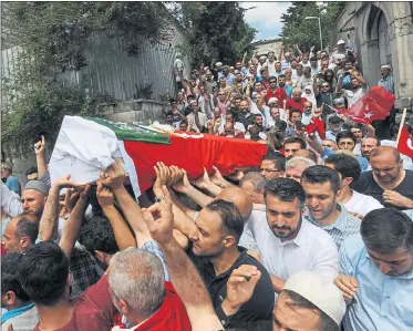  ??  ?? MOURNING: Relatives and friends carry the coffin, draped with the Turkish flag, of a victim of the thwarted coup in Istanbul.