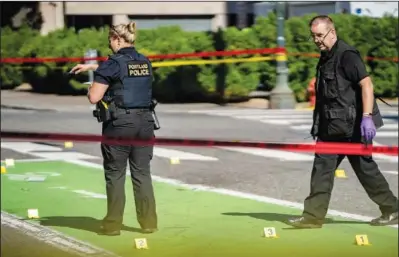  ?? (File Photo/The Oregonian/Mark Graves) ?? Police investigat­e an overnight fatal shooting July 17 in Portland. Portland is on track to shatter its record of 70 homicides set in 1987.