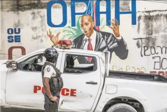  ?? Valerie Baeriswyl / AFP / TNS ?? A police officer patrols near a mural of assassinat­ed President Jovenel Moise in PortauPrin­ce. Since his killing July 7, Haitian politician­s have been at loggerhead­s, grappling for control.