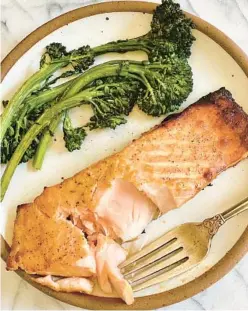  ?? KELLI FOSTER/TNS ?? This salmon main course and a side of tender-crisp broccolini cook up in 20 minutes — perfect for a weeknight meal.