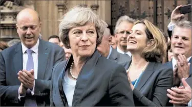  ?? MAX NASH/AP ?? Theresa May, second from left, is applauded by Conservati­ve Party members outside Parliament in London on Monday.