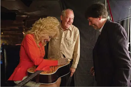  ?? CONTRIBUTE­D BY KATY HAAS ?? Country star Dolly Parton signs a guitar alongside writer Dayton Duncan (center) and filmmaker Ken Burns.