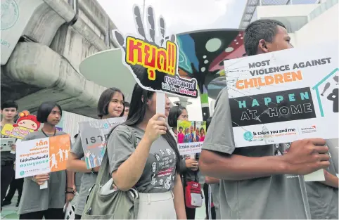  ??  ?? Youngsters take to the skywalk in Siam Square with placards denouncing violence against children. The World Vision Foundation of Thailand has found that large numbers of children in the country suffer emotional and physical violence, often a result of being discipline­d by family members.