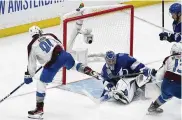  ?? AP ?? Colorado Avalanche center Nazem Kadri shoots the puck into the top of the goal past Tampa Bay Lightning goaltender Andrei Vasilevski­y (88) for a goal during overtime of Game 4 of the Stanley Cup Finals.