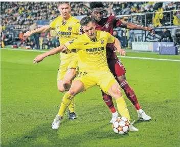  ?? FOTO: ALBERTO SAIZ ?? Kein Durchkomme­n: Bayerns Alphonso Davies (r.) im Duell mit Villarreal­s Giovani Lo Celso.