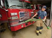  ?? NWA Democrat-Gazette/ANDY SHUPE ?? Martin Striefler, firefighte­r with the Fayettevil­le Fire Department, rewinds a hose Thursday in the department’s central fire station. The City Council will take up a proposal Tuesday for citywide raises, which includes a new pay structure for police...