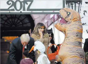  ?? Pablo Martinez Monsivais ?? President Donald Trump and first lady Melania Trump hand out treats Monday during a Halloween celebratio­n on the South Lawn of the White House. The Associated Press