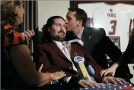  ??  ?? In this Dec. 13, 2016, photo, former Boston College baseball captain Pete Frates, center left, receives a kiss from Boston College head baseball coach Mike Gambino after Frates was presented with the 2017 NCAA Inspiratio­n Award.