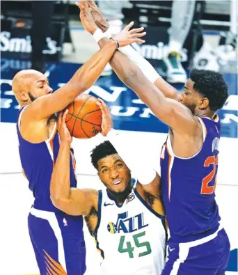 ?? AP PHOTO/ RICK BOWMER ?? The Phoenix Suns’ Jevon Carter, left, and Deandre Ayton, right, defend against Utah Jazz guard Donovan Mitchell during their preseason game Dec. 12 in Salt Lake City.