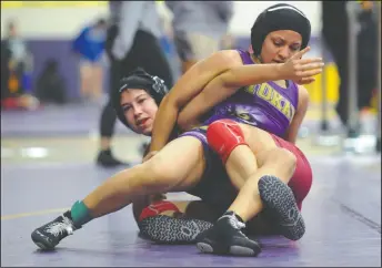  ?? PHOTOS BY BEA AHBECK/NEWS-SENTINEL ?? Above: Tokay's Jazmin Ruiz wrestles LIberty's Mary Lopez in their 121-pound match during the Tokay girls wrestling tournament at Tokay in Lodi Saturday. Below left: Tokay's Sarah Gonzalez wrestles Livingston's Alondra Zamora in their 121-pound match....