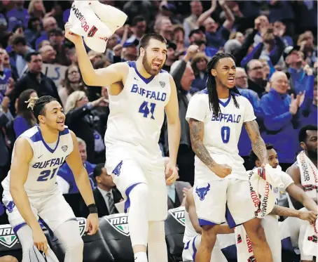  ?? THE ASSOCIATED PRESS ?? The Buffalo Bulls’ Dominic Johnson, left, and his teammates cheer during their victory against Toledo Saturday in Cleveland.