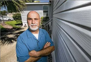  ?? RICHARD GRAULICH / THE PALM BEACH POST ?? School Police Officer Alex Lopez stands outside his home last week on the property of Dwight D. Eisenhower Elementary near Palm Beach Gardens. School renovation­s are forcing him to move. Lopez said he has invested tens of thousands in the home over the last 13 years.