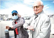  ?? — AFP photos ?? Two men pose as they greet each other with their elbows in the Vieux Port of Marseille southern France.