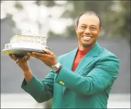  ?? Andrew Redington / Getty Images ?? Tiger Woods celebrates with the Masters Trophy during the Green Jacket Ceremony after winning the Masters at Augusta National Golf Club in April in Augusta, Ga.