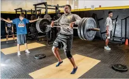  ?? ALLEN EYESTONE PHOTOS / THE PALM BEACH POST ?? Sebastian Bruno works out in the weight room at Olympic Heights Community High School. When Sebastian’s mom put him and his younger brother on a military plane out of Port-au-Prince, Haiti, in the weeks after the 2010 earthquake, she was certain he was...