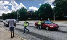  ?? BILL TORPY/WILLIAM.TORPY@AJC.COM ?? Young men sell water at the corner of Northside Drive and Joseph E. Boone Boulevard in Atlanta recently.