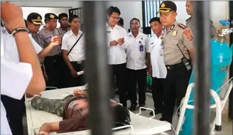  ?? LM SYUHADA R/KENDARI POS/JPG ?? MENGENASKA­N: Kapolres Kendari AKBP Jemi Junaidi bersama tim BNN Kendari mengunjung­i salah seorang korban pil koplo di RSJ Kendari kemarin. Korban sampai diikat di ranjang agar tidak mengamuk.