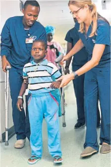  ?? ?? Mercy Ships staff help Diacko, a patient who travelled 300 miles to have surgery on Africa Mercy in Senegal