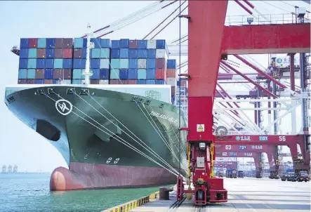  ?? CHINATOPIX VIA AP ?? A ship hauls containers at a port in Qingdao in eastern China’s Shandong province. Without the means to match the U.S. on tariffs, China is using other tools such controllin­g its currency.