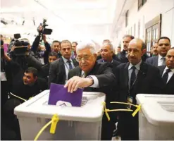  ?? — AFP ?? RAMALLAH: Palestinia­n president Mahmud Abbas (C) casts his vote at the Muqataa, the Palestinia­n Authority headquarte­rs.