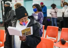  ?? Pittsburgh Post-Gazette ?? Martha Hunter, of the Hill District, and others wear masks as they attend a lunchtime worship service Thursday at St. Moses the Black Orthodox Church.