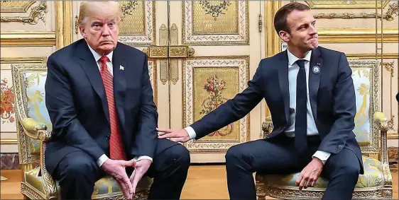  ??  ?? TOUCHY: President Macron tries to ease the tension by reaching out to pat Mr Trump’s thigh, but the US leader looks distinctly unimpresse­d by the gesture