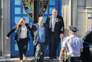  ?? AP PHOTO ?? Harvey Weinstein, second left, is loaded into an unmarked vehicle while leaving the first precinct of the New York City Police Department after turning himself to authoritie­s following allegation­s of sexual misconduct, Friday in New York.