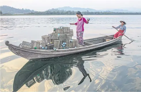  ??  ?? Ethnic Shan-ni women set shrimp traps in Indawgyi Lake in Kachin State of Myanmar.