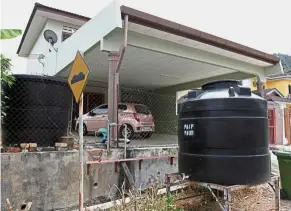  ??  ?? Constant pain: Tanks are seen outside a house in Taman Raub Jaya 6 where residents have to deal with the frequent water cuts.