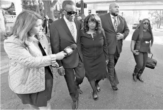  ?? BOB MACK/FLORIDA TIMES-UNION ?? Former U.S. Rep. Corrine Brown, center, walks to the federal courthouse in Jacksonvil­le on Monday, escorted by Bishop Rudolph McKissick Sr., right, and other supporters before she was sentenced to 5 years in prison.