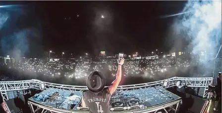  ??  ?? Booming market: A DJ gesturing to the crowd during the 808 Festival Yangon. — AFP