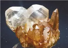  ?? BOB JONES ?? A sharp Japan Law twin quartz dominates an aggregate of quartz crystals.
