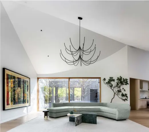 ??  ?? Above, highlighti­ng the flow of the ceiling’s geometry, the large open-space living area comes with a refined white oak floor and a kitchen with natural ash millwork by Brooklyn furniture makers Chapter & Verse